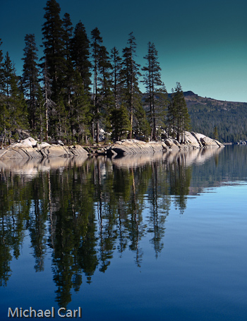 Trees reflected on claim waters of  Lake Alpine