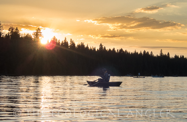 Sun sets near Lassen Peak as fishermen search Lake Almanor for rising trout.