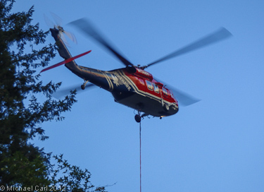 A helicopter lowers a bucket on the Upper Sacramento River