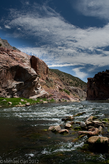 The Wind River Canyon tall rock walls raise above the river.