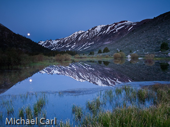 A full moon reflects off the beaver pond in a Sierra Nevada valley